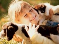 Close-up of a girl holding a puppy and a kitten